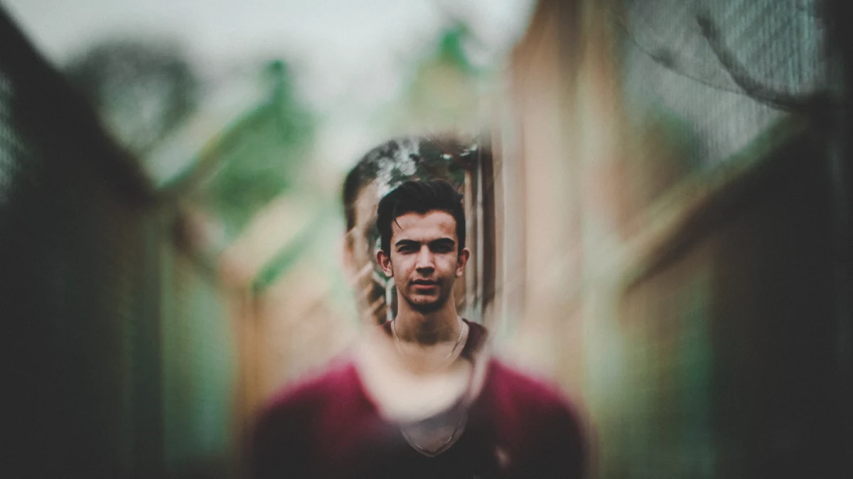 A portrait framed by softly blurred leaves
