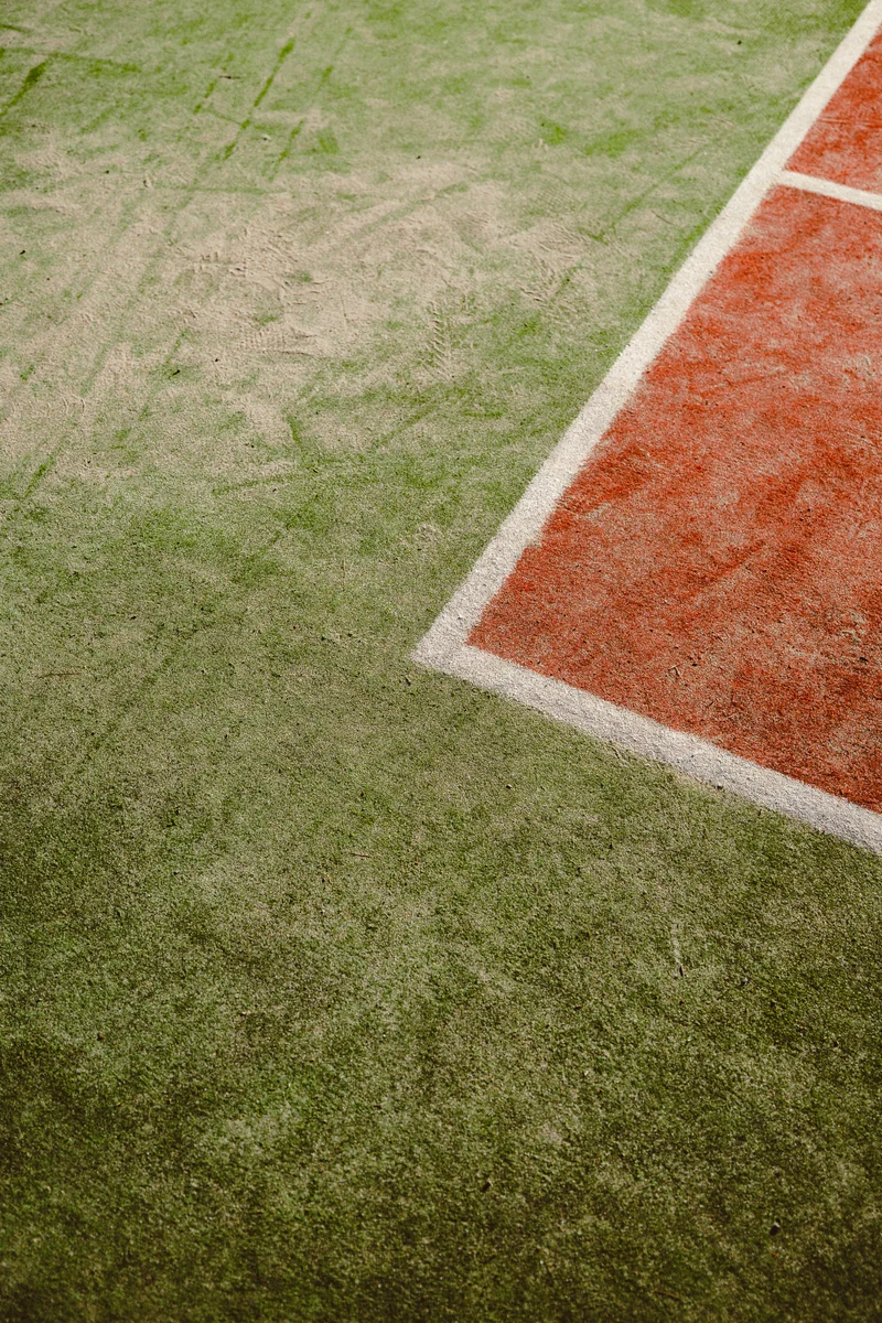 White boundary lines on a green and red tennis court