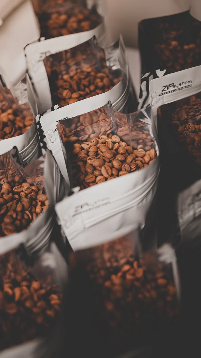 Open silver bags filled with roasted coffee beans